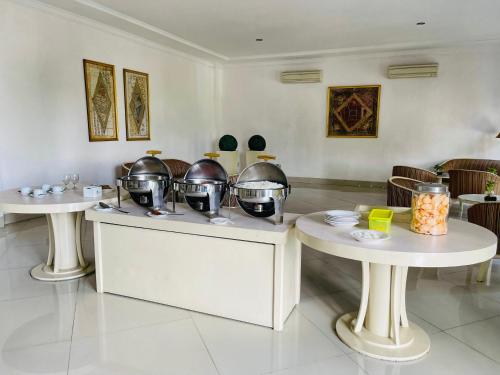 una habitación con dos mesas con ollas y sartenes en aresidencia sei putih, en Medan