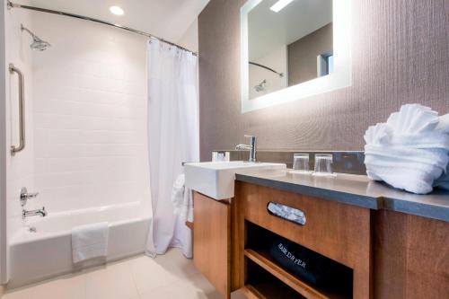 La salle de bains est pourvue d'un lavabo, d'une baignoire et d'un miroir. dans l'établissement SpringHill Suites by Marriott Gallup, à Gallup