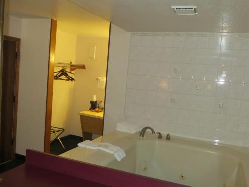 a bathroom with a bath tub and a mirror at Silver Saddle Motel in Manitou Springs