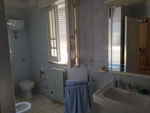 bagno con lavandino, servizi igienici e specchio di Dimora Maria a Copertino