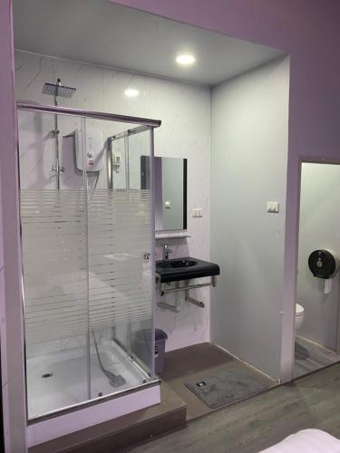 La salle de bains est pourvue d'une douche en verre et d'un lavabo. dans l'établissement Mekong Riverside, à Vientiane