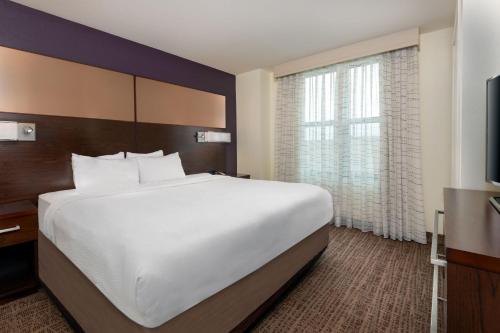 a bedroom with a large bed and a large window at Residence Inn by Marriott Charlottesville Downtown in Charlottesville