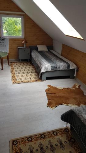 a attic bedroom with two beds and a window at Turystyczny apartament na poddaszu in Skoczów
