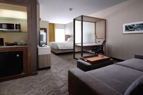 a hotel room with a bed and a living room at SpringHill Suites by Marriott San Antonio Northwest at The RIM in San Antonio