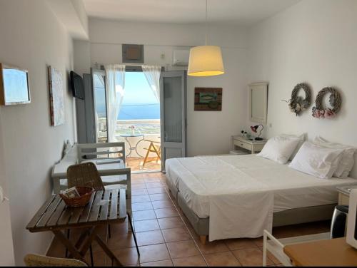 a bedroom with a bed and a view of the ocean at Alonia Studios in Firostefani