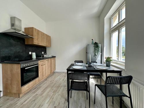 uma cozinha com uma mesa, cadeiras e um fogão em Kröpi 8 em Bad Doberan