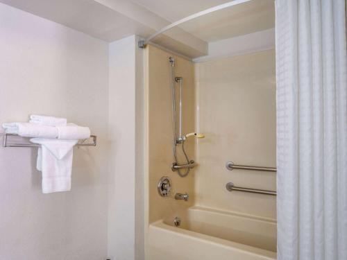 La salle de bains est pourvue d'une douche, d'une baignoire et de serviettes. dans l'établissement Days Inn by Wyndham Clemson, à Clemson