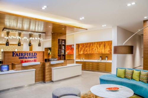 a living room with a blue couch and a table at Fairfield Inn & Suites Queretaro Juriquilla in Querétaro