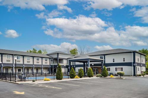 a large white building with a parking lot at Days Inn & Suites by Wyndham Niagara Falls/Buffalo in Niagara Falls