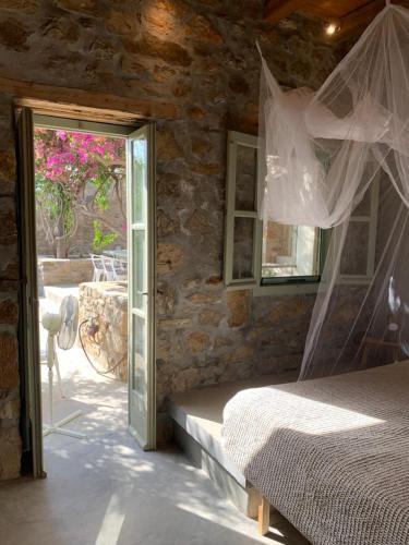 a bedroom with a bed and a sliding glass door at Mandri B&B in Serifos Chora