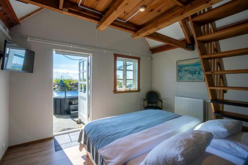 um quarto com uma cama e uma escada em Hlid Fisherman's Village em Álftanes