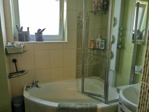 a bathroom with a shower and a tub and a sink at Apartament Woda Morska in Ustka