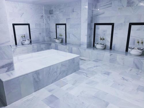 a white bathroom with three sinks and two toilets at Z&A kılıç apart otel in Dargeçit
