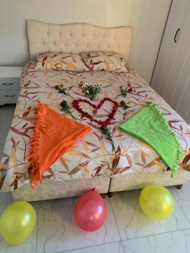 a bed with balloons on it with a heart made up at Z&A kılıç apart otel in Dargeçit
