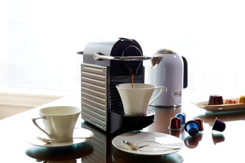 a coffee maker with two cups on a table at The Ritz-Carlton Osaka in Osaka