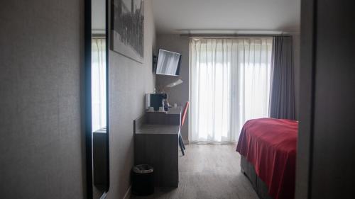 a bedroom with a red bed and a window at Schaluinenhoeve in Baarle-Nassau