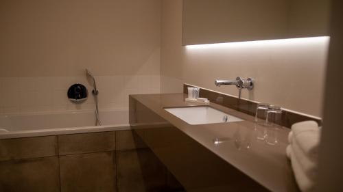a bathroom with a sink and a bath tub at Schaluinenhoeve in Baarle-Nassau