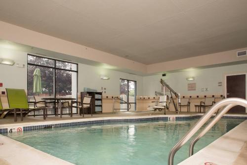 une grande piscine avec des chaises et une table dans l'établissement SpringHill Suites by Marriott Billings, à Billings