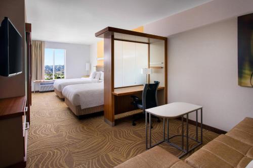 a hotel room with a bedroom with a bed and a desk at SpringHill Suites by Marriott Los Angeles Burbank/Downtown in Burbank