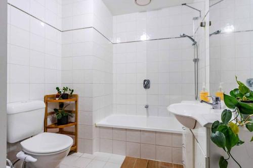 uma casa de banho com uma banheira, um WC e um lavatório. em Ocean view apartment close to CBD with indoor pool. em Melbourne