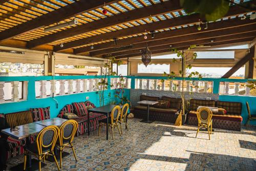 a restaurant with blue walls and tables and chairs at Daher Guest House Nazareth in Nazareth