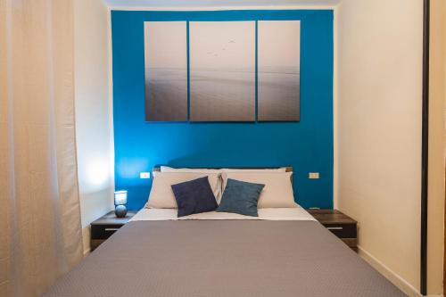a bedroom with a large bed with a blue wall at Il Borgo degli Artisti in Montoro Inferiore