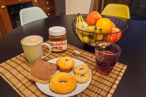 een tafel met een bord donuts en een fruitschaal bij Il Borgo degli Artisti in Montoro Inferiore