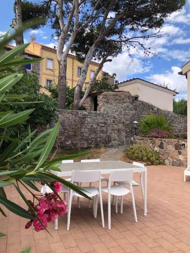 a white table and chairs on a patio at Casa Rais Dragut in Capraia