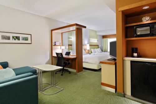 a hotel room with a bed and a desk and a couch at SpringHill Suites by Marriott Pensacola in Pensacola