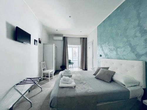 1 dormitorio con 1 cama grande y pared azul en B&B I Borbone, en Nápoles