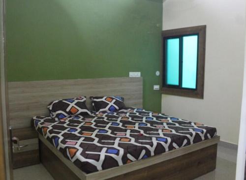 een slaapkamer met een bed met een dekbed en een raam bij SPOT ON Hotel Imperial Crown in Sūbedārganj