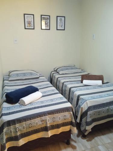 - un groupe de trois lits dans une chambre dans l'établissement Rioli quarto 2, à Caruaru