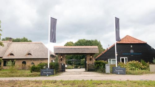 a building with two flags in front of it at Schaluinenhoeve in Baarle-Nassau