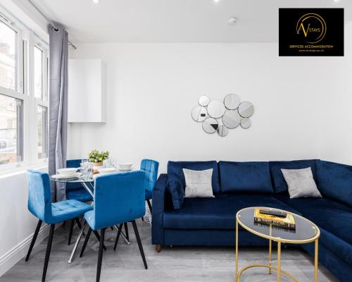 - un salon avec un canapé bleu et une table dans l'établissement 2 Bedroom Apartment by AV Stays Short Lets Southwark London, à Londres