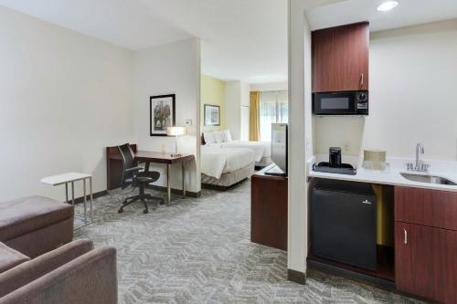 a hotel room with a bed and a desk at SpringHill Suites Milford in Milford