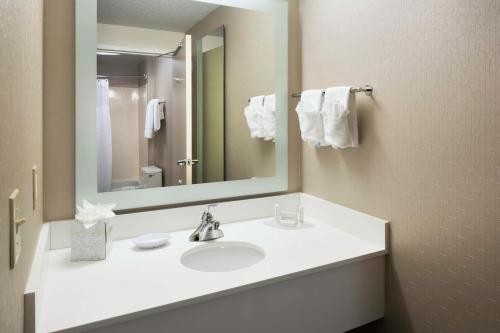 een badkamer met een witte wastafel en een spiegel bij SpringHill Suites Milford in Milford