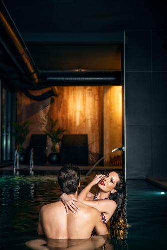 a man and woman in the water in a pool at 21st Century Zlatibor Residence, Spa & Wellness by Adora in Zlatibor