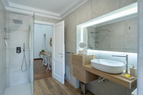 ein Badezimmer mit einem weißen Waschbecken und einer Dusche in der Unterkunft MareLuna Apartment in Neapel