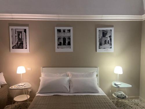 a bedroom with a bed with three pictures on the wall at B&B Porta Baresana in Bitonto