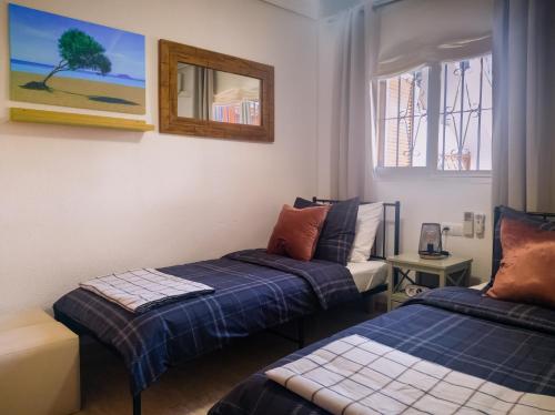 1 Schlafzimmer mit 2 Betten und einem Wandspiegel in der Unterkunft Amigos I at Veramar 6 in Vera