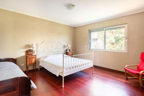 a bedroom with a white bed and a window at Casa da Vigia in Santo António
