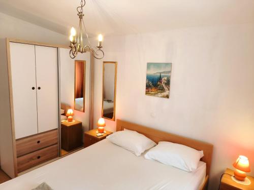 um quarto com uma cama branca e 2 candeeiros em Villa Merica em Trogir