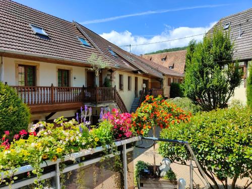 a house with a bunch of flowers in the yard at GÎTE DE LA FONTAINE in Wangen