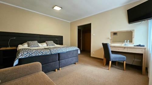 um quarto com uma cama, uma secretária e uma cadeira em Hotel Sypniewo em Margonin