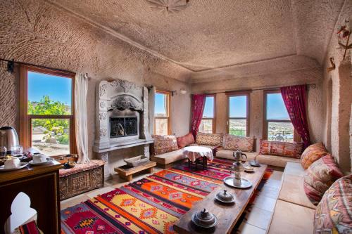 a living room with a couch and a fireplace at Cappadocia Fairy Chimneys Selfie Cave Hotels - Special Class in Uçhisar