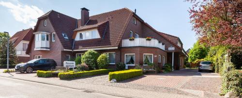 a brick house with a car parked in front of it at Pension Wilken in Bad Zwischenahn