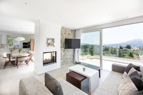 a living room with a couch and a fireplace at Villa Inati in Nípos