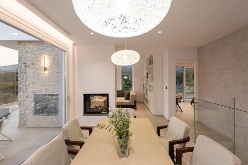 a dining room with a table and chairs and a fireplace at Villa Inati in Nípos