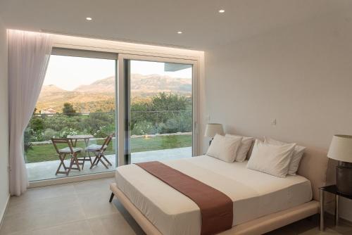 a bedroom with a bed and a large window at Villa Inati in Nípos