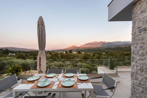 a dining room with a table and views of the mountains at Villa Inati in Nípos
